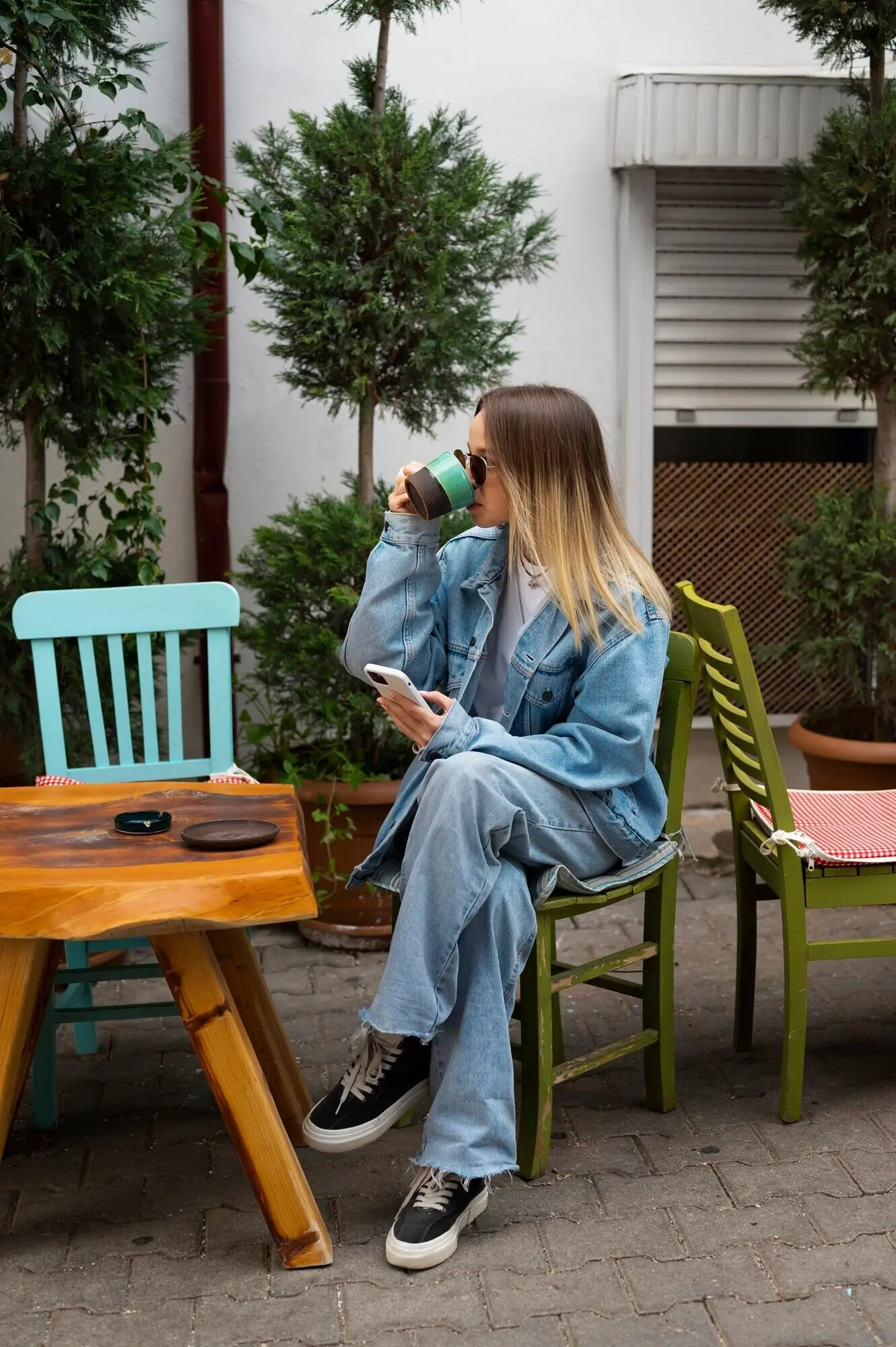 Totaalshot van een vrouw in een volledige denimoutfit.